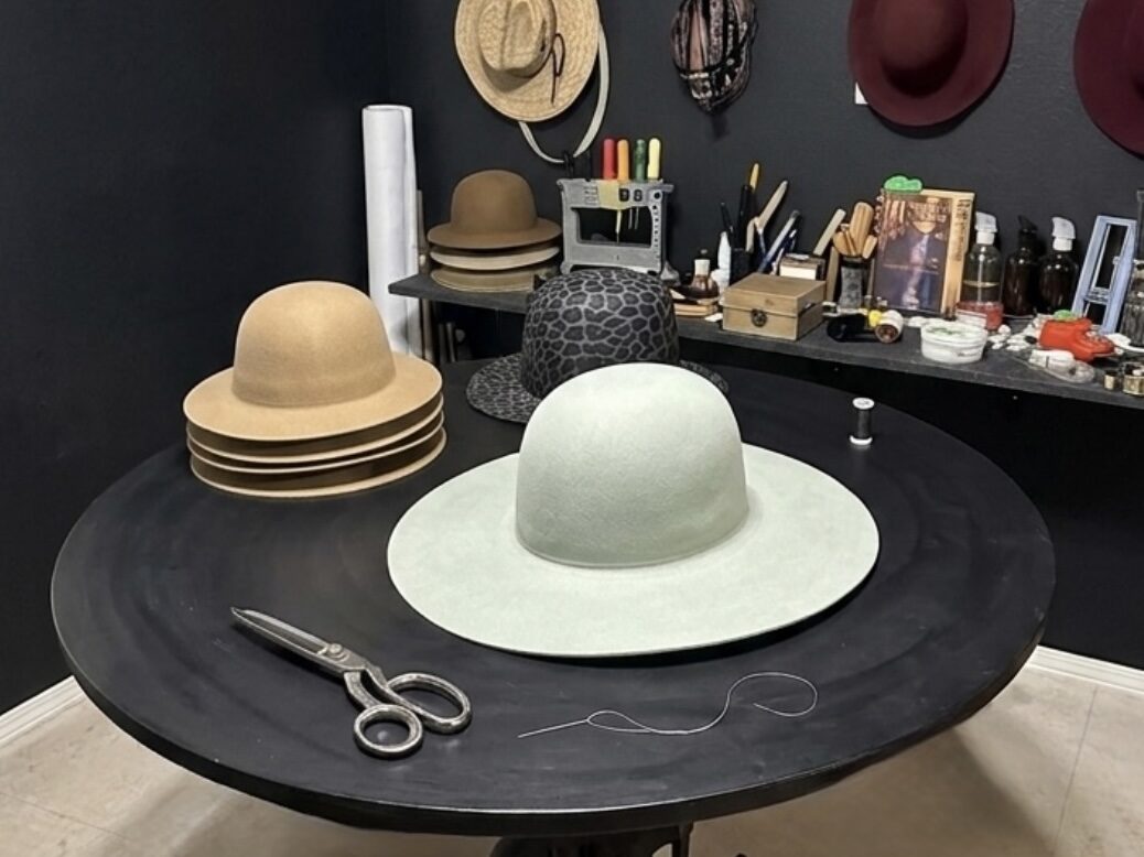 Hands shaping fur-felt by hand in the studio