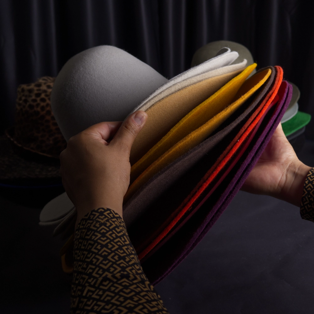Hands shaping fur-felt by hand in the studio